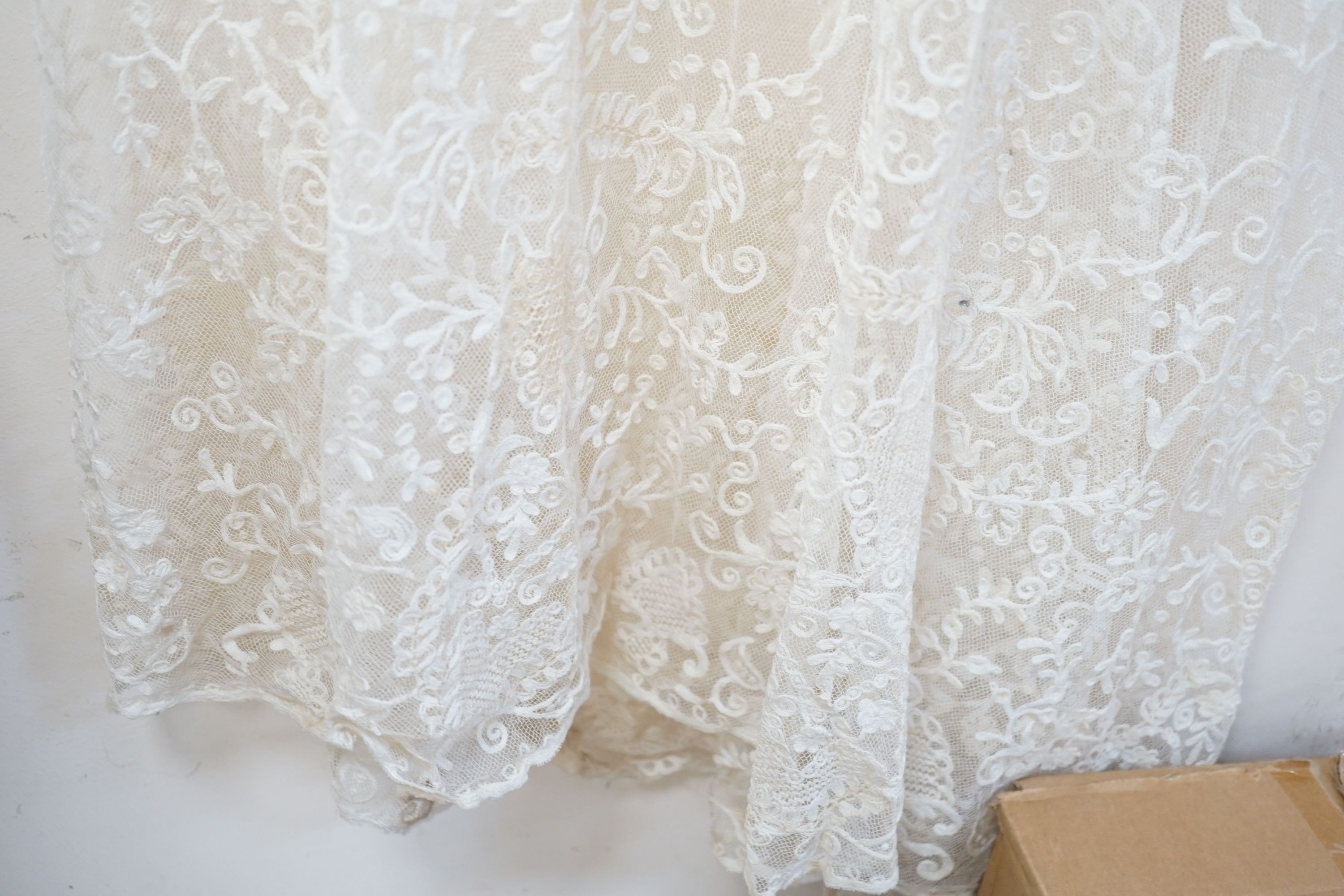 An early 20th century needle run on net lace wedding dress, 155 cms long.